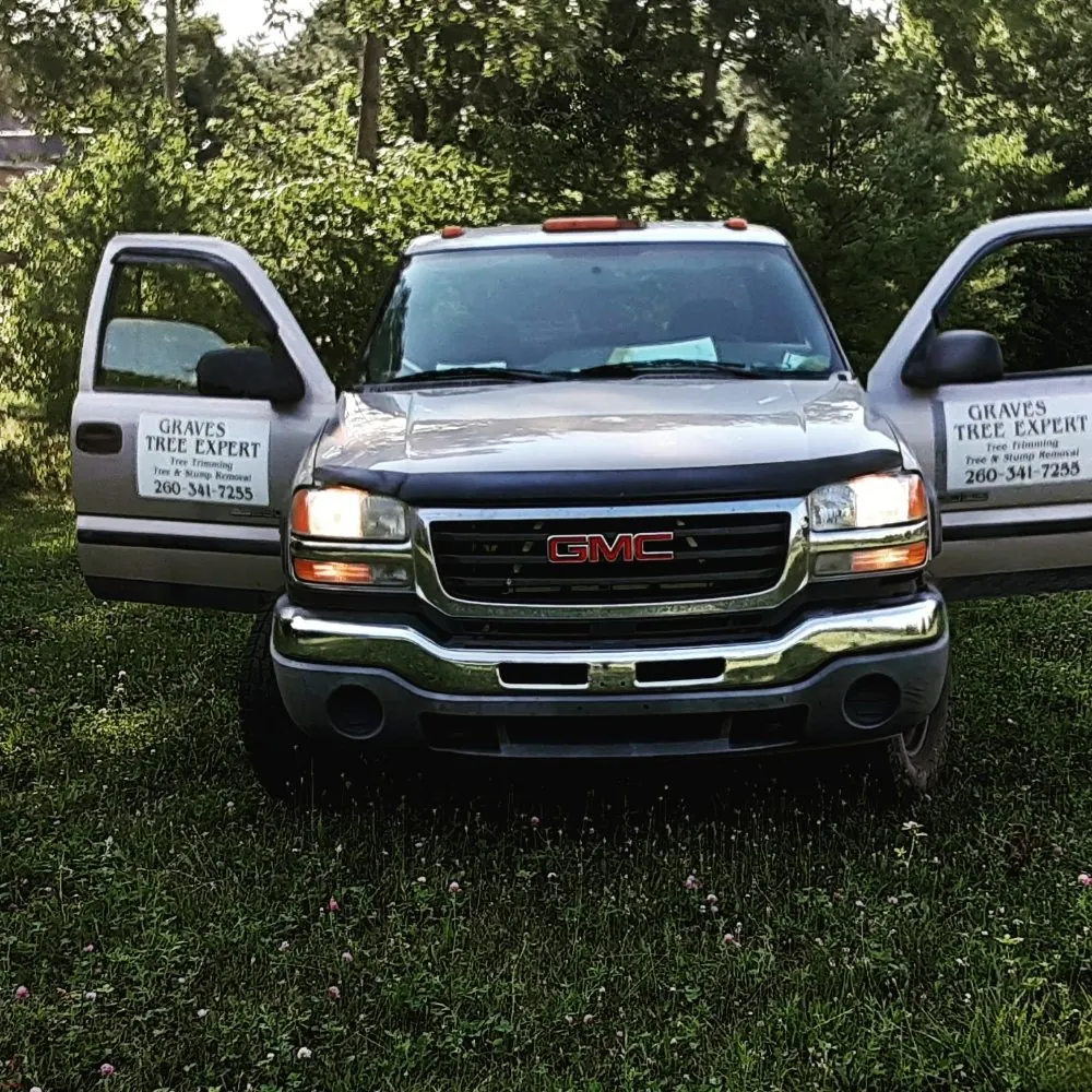 Silver GMC pickup with Graves Tree Expert signs on both doors